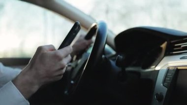 Adam araba kullanırken Smartphone 'da mesajlaşıyor. E-posta sohbetlerini ve haberleri kontrol ediyorum. Araçtaki Erkek Mesaj Yazıyor Sosyal Ağ Sohbetleri Cep Telefonundan. Sosyal medyada Araba Kullanmak ve Mesajlaşmak