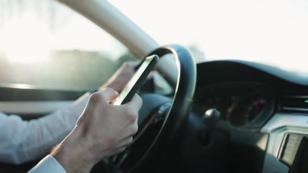 Κοντινά χέρια αγνώριστου ανθρώπου πληκτρολογώντας online μήνυμα χρησιμοποιώντας το κινητό τηλέφωνο, ενώ κάθεται στο αυτοκίνητο. Closeup άποψη του επιχειρηματία χρησιμοποιώντας το τηλέφωνο στο auto. Ασφάλιση ατυχήματος. Συνομιλία οδηγού — Αρχείο Βίντεο