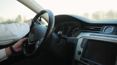 Yaz ışığında direksiyonda direksiyon sallayan erkek sürücülerin yakın görüntüsü. Adam nano araç kullanıyor. Otomatik taşıma. Yönlendirme. İş adamı yalnız seyahat ediyor.