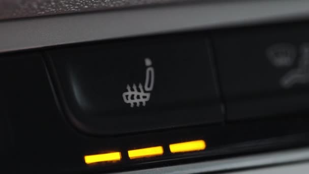 เปิดปุ่มทําความร้อนที่นั่งในรถ สลับที่นั่งอุ่นของรถโดยการกดปุ่ม แดชบอร์ดที่นั่งอุ่นในรถ . — วีดีโอสต็อก