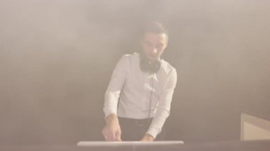 Sakallı DJ mikser kontrolörünün önünde duruyor, gece kulübünde yeni bir karışım hazırlıyor. Vokalist kadın müzik grubu, saksafoncu saksafoncu, DJ adam ışıklarla konserde şarkı söylüyor..