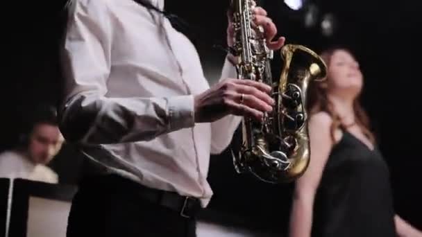 Musique de groupe dansant, chantant sur scène sur scène avec de la fumée. Dj se produit en concert de fête. Le saxophoniste joue sur le saxophone doré. Spectacle live — Video