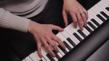 Piyanistlerin yakın çekimi profesyonel olarak piyano çalar. Piyanist büyük bir piyano çalar. İki el, kuyruklu piyanoda hafif klasik müzik çalar. Profesyonel piyanist..