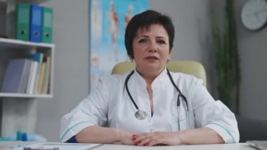 Bayan doktor çevrimiçi video görüşmesi hastasına danıştı. Kadın terapist kamerayla uzaktan sohbet ederek video konferans yapıyor. Teletıp, tele sağlık. Web kamerası görünümü.