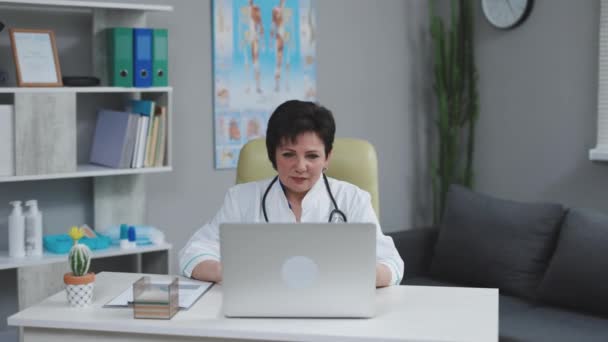 女医生做网上视频咨询病人。远程医疗，远程保健。欧洲女医生在远距离交谈中对着摄像机说话.现代医疗概念. — 图库视频影像