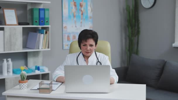 Doctora haciendo videollamadas en línea consultando paciente. Telemedicina, telesalud. Terapeuta europea hablando con la cámara en el chat remoto. Concepto medecino moderno. — Vídeo de stock