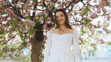 Güneş ışığında uzun saçlı genç bir kadının portresi. Gülümseyen kameraya bak. Moda mankeni bayan kozmetik güzellik mutlu mutlu, süper yavaş çekim 100 fp 4k.