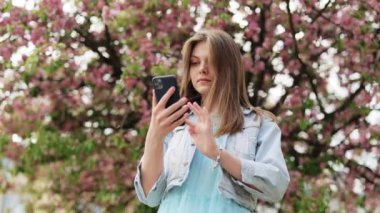 Mutlu kadın portresi cep telefonunda başarıdan zevk alır. Kapalı çekim neşeli kız telefonda iyi haberleri ağır çekimde okuyor. Şaşkın kadın telefonda zaferi kutluyor.