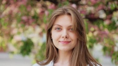 Dışarıda kameraya bakan gülümseyen genç kadın mutlu kız portresi güzel modern kadın.