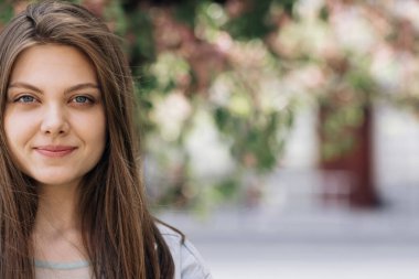 Dışarıda bekleyen çekici bir kadının güzel yüzü. Saçları rüzgarda savrulan çekici bir genç bayan. Yaratıcı makyajı ve dudaklarında pembe ruju olan mükemmel bir model. Etnik.