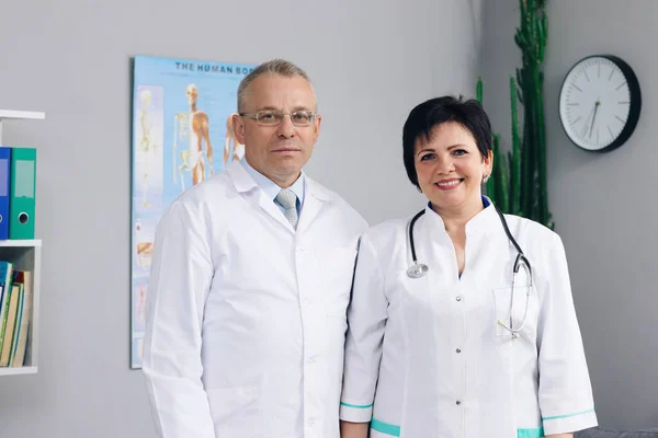 Médicos de mujeres y hombres. Médicos internacionales trabajadores sanitarios. Médicos y enfermeras mirando la cámara. Equipo de la clínica. Docs en el trabajo en el hospital —  Fotos de Stock