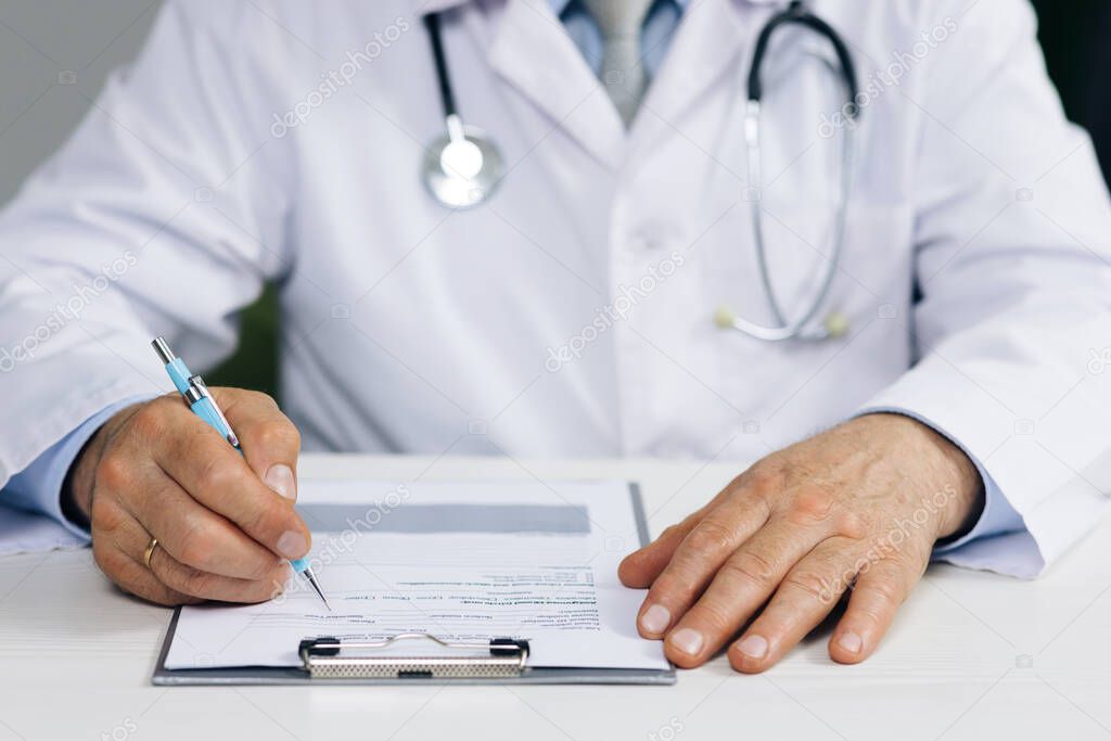 Close up wrinkled male doctor writing information in medical registration journal. Confident old mature male doctor physician therapist working at office, handwriting notes