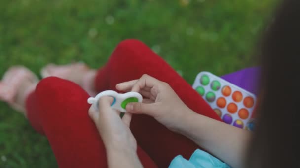 Çocuklar için basit bir gamzeli popit stres önleyici oyuncak. Oyuncak ile oynayan kız elleri. Düğmelerle popüler bir oyun oynamanın tepe noktası, stres önleyici bir oyuncak. Eğitimsel çocuklar oyunları — Stok video