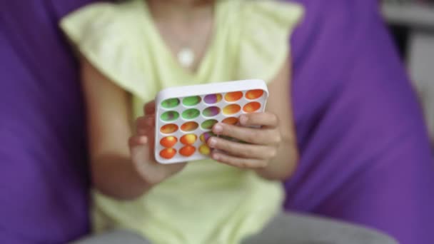 Pop it simple dimple popit anti-stress sensory toy for children. Girl hands playing with toy. Topview of playing a popular game with buttons, an anti-stress toy. Educational childrens games — Stock Video