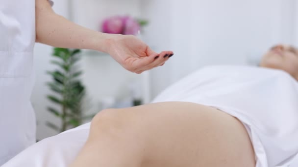 Close up Massagem terapêutica da perna feminina. Mãos femininas fazendo massagem profissional a uma mulher em uma mesa de massagem. Tratamento de beleza — Vídeo de Stock