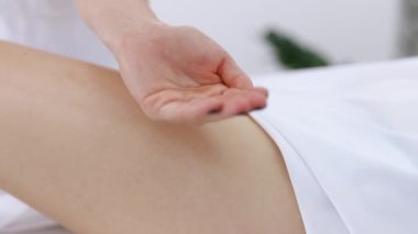 Usta masör kız için anti-selülit masajı yapıyor. Güzellik stüdyosundaki kadın kalçasına el yapımı anti-selülit masajı.