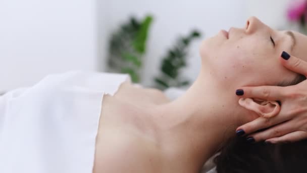 Donna sdraiata sul letto spa ottenere un trattamento di massaggio facciale con aroma olio essenziale cura della pelle dal massaggiatore al salone di bellezza. Benessere massaggio corpo e concetto di spa viso — Video Stock