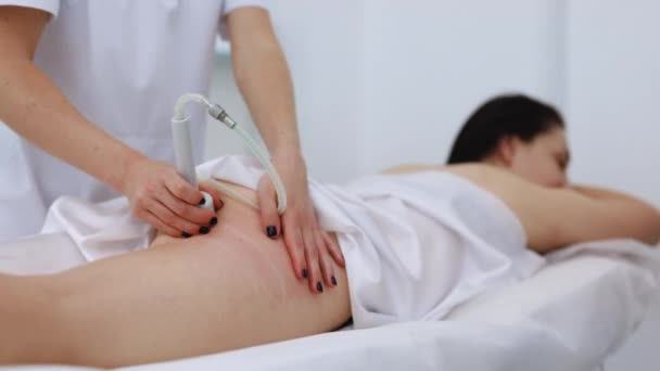 진공 롤러 마사지 허벅지와 엉덩이 마사지를 받고 있는 여성 이 반 세포 조직 마사지를 받는 중이다. 온천 미용실 침대에 누워 있는 여성 이 리무진 마사지를 받고 있습니다. 화선 치료 — 비디오