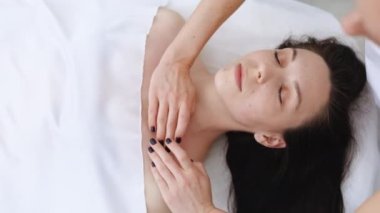 Kapalı kapılar ardında masaj yapan kadın masaj yapıyor. Güzellik salonunda masaj yaptırmaya hazırlanıyor. Hoş bir kadın kanepeye uzanıyor ve cilt ve vücut bakımının keyfini çıkarıyor..