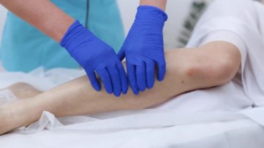 Genç fizyoterapist kadın yaralanmalardan sonra fiziksel egzersize yardım ediyor. Rehabilitasyon. Tedavi Sağlık Hizmetleri Konsepti