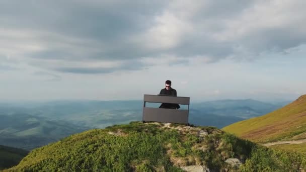 Flygfoto av pianisten spelar på flygeln i bergen. Man två händer spelar mild klassisk musik på en flygel på naturen. Professionell pianist. Man rör fingrarna på tangenterna — Stockvideo