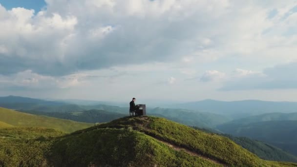 사람의 두 손을 공중에서 보면 자연계에 있는 웅장 한 피아노 에 부드러운 고전 음악을 연주 한다. 피아니스트는 산에서 그랜드 피아노로 연주 합니다. 전문 피아니스트. 사람은 열쇠에 손가락을 터치 — 비디오