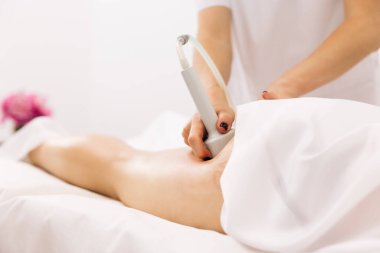 Kadın anti-selülit ve anti-yağ tedavisi görüyor. Anti-selülit yapan kadın fizyoterapist genç bir kadının kalçalarına ve kalçalarına masaj yapabilir. Sağlık kavramının bakımı ve bakımı.