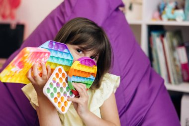 Renkli ve parlak, basit bir gamzesi var. Modern popit oyuncağı olan küçük bir kız portresi. Son moda stres önleyici oyuncaklar itin ve çocukların eline basit gamzeler verin.