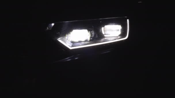 Auto met koplamp Flitsen soepel close-up. Auto vooraan Led Light. Auto koplampen Knipperende Led Lamp. Schakelen van auto LED-koplampen in de nacht. Nieuwe moderne autokoplamp — Stockvideo