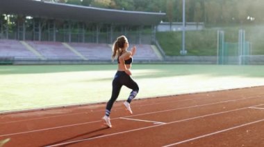 Atletizm pistinde antrenman yapan bayan koşucu. Yaz sabahı vakti stadyumda koşan atletik bir kadın. Eğitim sırasında hipodromda koşan formda bir kadın. Sporcu Kadın