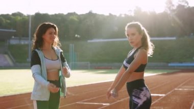 Yüzünü kameraya çeviren güzel genç kadınların portresi. Beden eğitiminden sonra kameraya bakan güzel kızlara yakın durun. Sağlıklı kadın yaşam ve açık hava spor konsepti