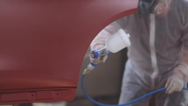 빨간 차는 수리하는 동안 페인트 실에 있다. 자동화 페인팅 노동자. 전문적 인 자동차화 가는 몸을 색칠하는 것입니다. 남성 기술자는 공기 페인팅 자동차 문입니다 — 비디오