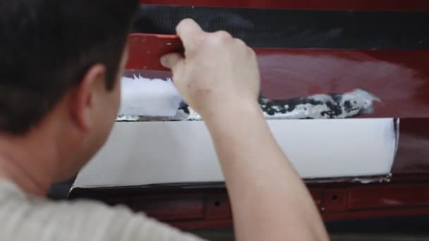Tamirci arabayı tamir etti. Araba gövdesini tamir ediyorum, macun sürüyorum. Kazadan sonra boyamadan önce astar zımparalamayla çalış — Stok video