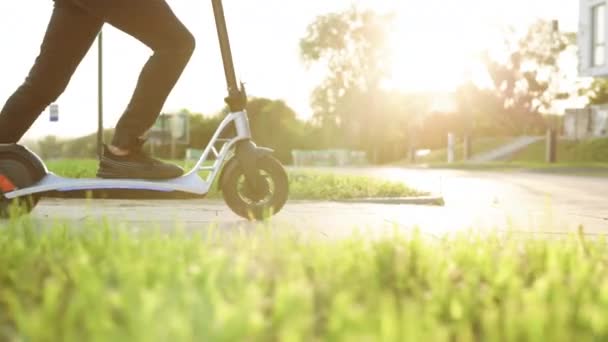 Close up - Male riding electric scooter. Modern transportation gadget and popular futuristic device among young people. Attractive man stands, scoots and rides on the electric kick scooter. — Stock Video