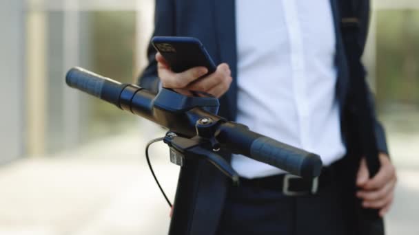 Oigenkännlig man ta hyra elektrisk sparkcykel NFC kontaktlös skåp på cykel cykel cykel i att dela parkeringsplats, turist telefon ansökan. Delning företag ekotransport i staden — Stockvideo