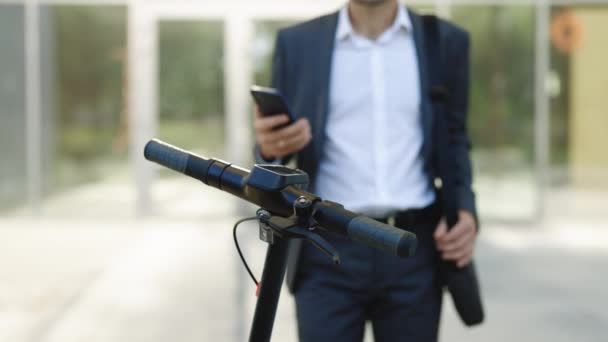 Irriconoscibile uomo d'affari prendere noleggio scooter elettrico calcio NFC armadietto contactless in bicicletta in condivisione parcheggio, applicazione telefono turistico. Condividere l'eco-trasporto aziendale in città — Video Stock