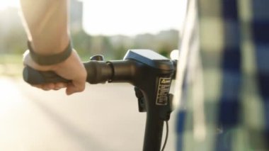 POV şehir sahilinde çevre dostu bir e-scooter kullanıyor. Genç hippi gün doğumunda elektrikli mobilete biniyor. Çevre dostu ulaşım. Hızlı sürüş elektrikli taşıma