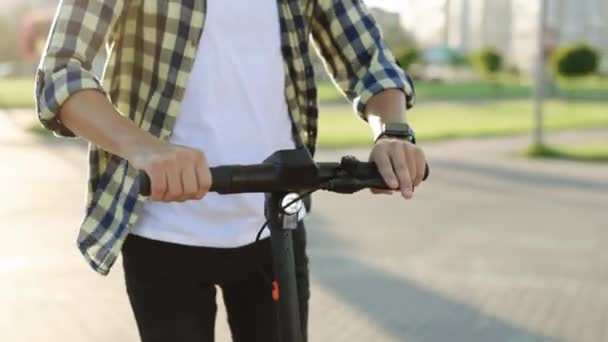 Elektrikli scooter 'a binen tanınmayan adam. E-Scooter Sürücüsü Kiralık Kişisel Çevre Taşımacılığı. Ekoloji Taşımacılığı Sürücüsü. Şehirde erkek elektrikli scooter sürücüsü. Dışarıdaki araçta stil sahibi adam. — Stok video