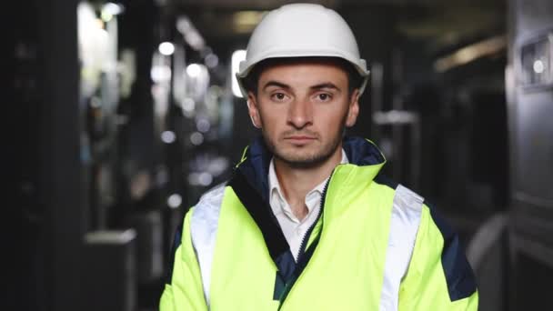 Retrato de un trabajador esencial de primera línea en un almacén. Gente de negocios caucásicos en sombrero duro o ropa de seguridad. Especialista profesional en ingeniería industrial masculina. Disparo en cámara lenta y 4k — Vídeos de Stock