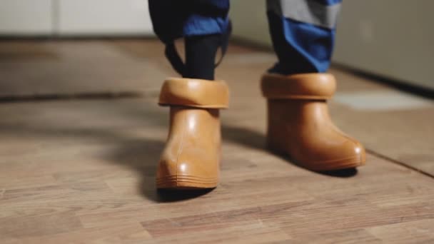 Elektrikář nosí gumové boty. Elektrický technik si obléká speciální ochranné boty. Vysokonapěťová elektrárna. Koncepce vývoje elektráren — Stock video