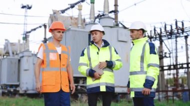 Baş mühendis ve uzmanlar elektrik santrali inşaatı için yatırım raporunu öğreniyorlar. İş ekibi. Pazarlık. Endüstri. Profesyonel mühendisler yenilikçi projeyi tartıştılar.