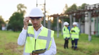 Başarılı Müteahhit Yatırım Mühendisi Sert Şapka ve Güvenlik Yeleği Giyen Bir Ticari İnşaat Alanında Duran Çapraz Silahlar Tablet Bakır Bilgisayarını Güvenle Tutar
