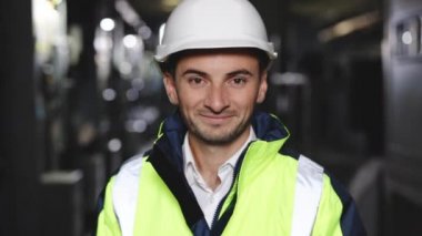 Çelik Fabrikasında Üniforma ve Sert Şapka Giyen Mutlu Profesyonel Ağır Sanayi Mühendisi İşçisi. Gülümseyen Kafkas Endüstri Uzmanı Metal İnşaat Üretiminde Duruyor