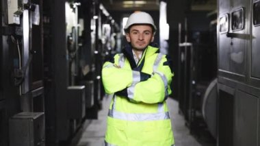 Kafkas ağır sanayi işçisinin zoom portresi. İnşaat alanında çalışırken kameraya güvenerek gülümsüyor. Yüksek voltajlı elektrik santrali. Elektrikçi, elektrik işçisi..