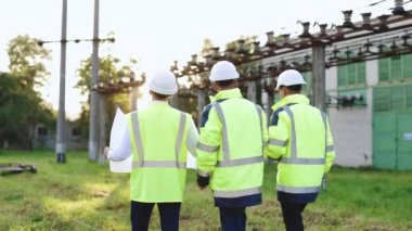 İnşaat alanının ortasında bulunan çeşitli uzmanlardan oluşan bir grup, inşaat planını birlikte analiz ediyorlar. Elektrik endüstrisi, elektrik enerjisi üretim konsepti
