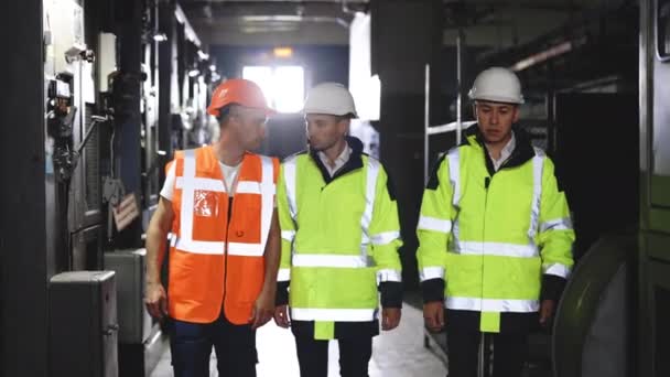 Skupina chytrých tří inženýrů s perfektním bezpečnostním jednotným nápadem na brainstorming, kteří plánují řídit projekt průmyslu. Pracují v elektrárně. — Stock video