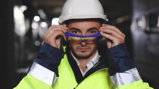 Портрет професійного кавказького інженера важкої промисловості працівника в уніформі безпеки, окулярах і жорсткому капелюсі. впевнений промисловий спеціаліст на заводі — стокове відео