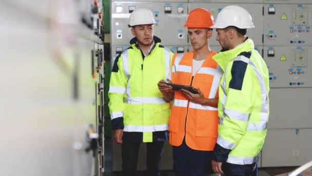 Ingeniería profesional discutir la inspección con el equipo de ingenieros en el área de la fábrica de maquinaria de sala limpia. Trabajador mano uso tableta listenreport papel para la auditoría interna. Central eléctrica de alto voltaje — Vídeo de stock