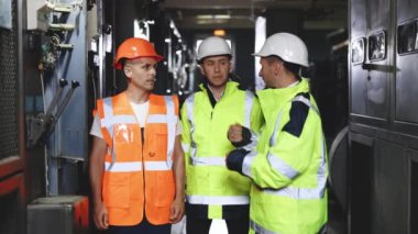 Mükemmel güvenlik üniformasına sahip üç mühendis ekibi endüstri fikir planlama projesi üzerinde kafa patlatıyorlar. Üniformalı ve miğferli mühendisler elektrik istasyonunu teftiş ediyorlar.