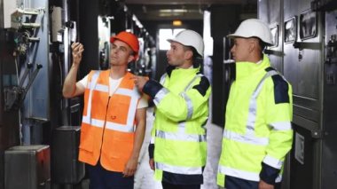 Endüstriyel erkek profesyonel mühendisler çalışmanın verilerini tartışırlar. Mükemmel güvenlik üniformasına sahip üç mühendis ekibi endüstrinin fikir planlama projesini araştırıyor..